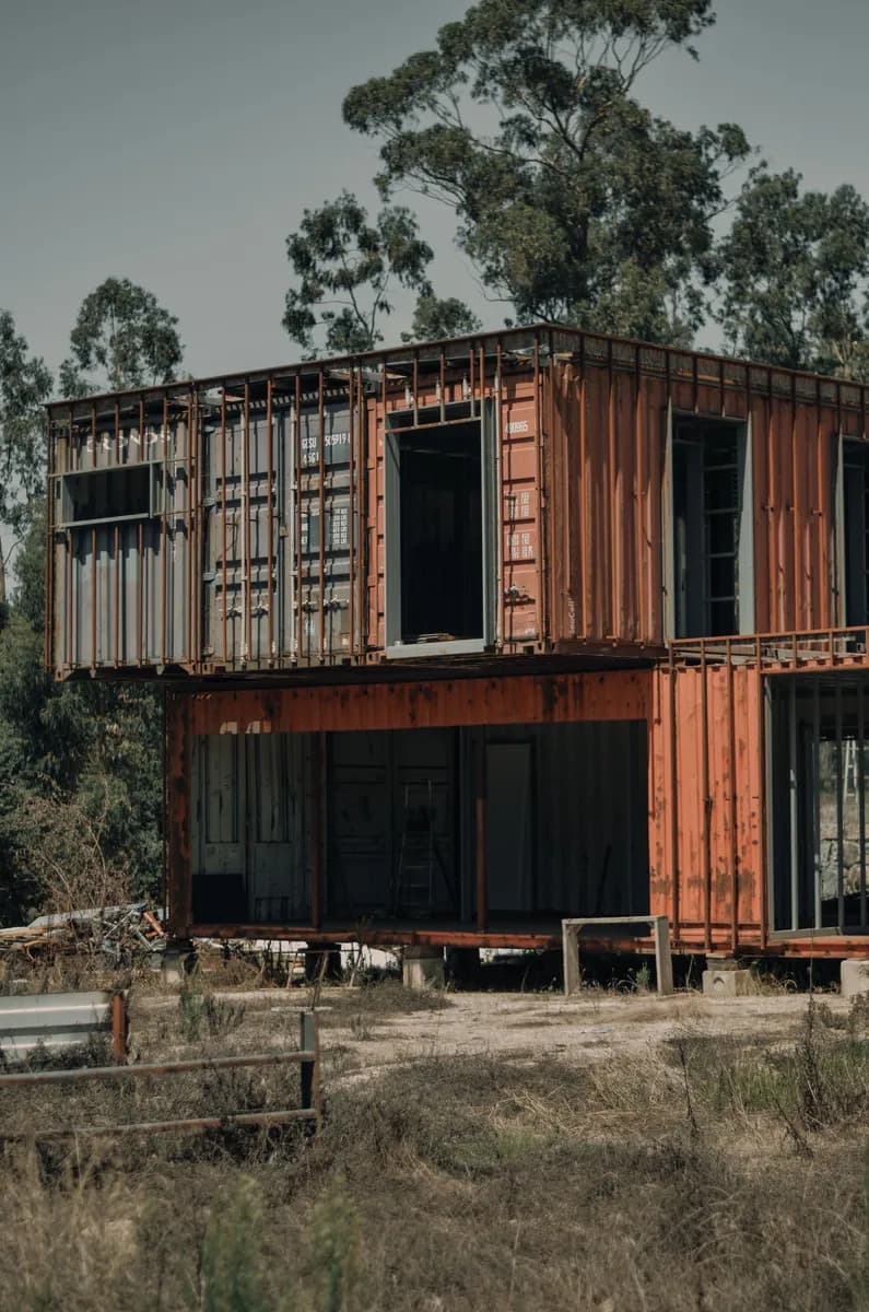 BookNoFees-voorbeeldbeeld: Twee-verdieping-containerhuis met groot vensters tussen bome