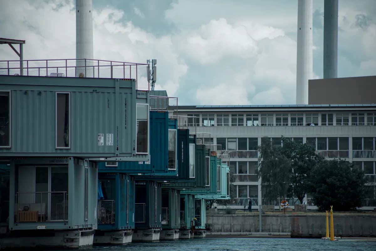 BookNoFees-voorbeeldbeeld: Kleurvolle containerwoonstelle met 'n pier by die water