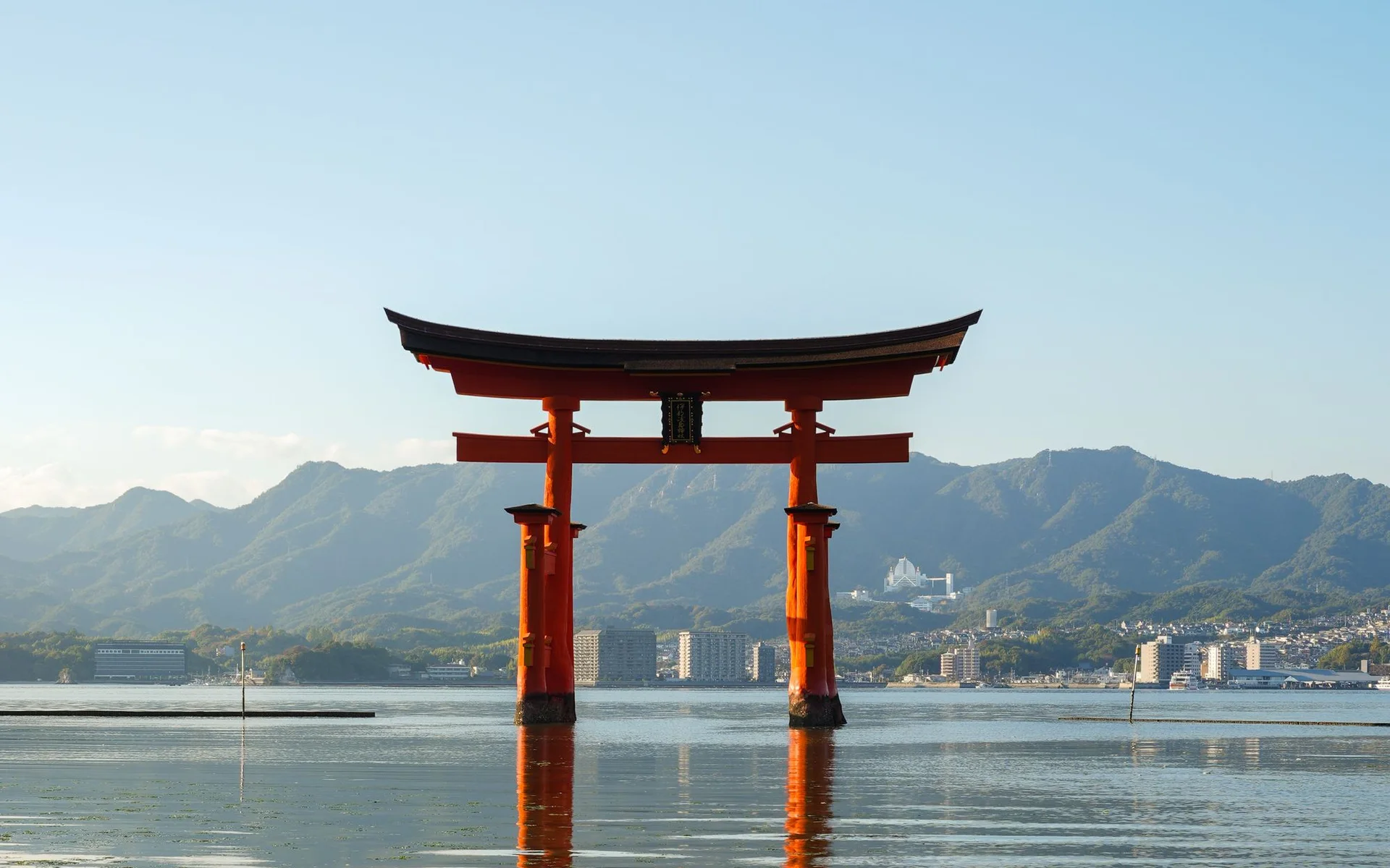 Torii by Itsukushima-heiligdom wat bo die water uitrys