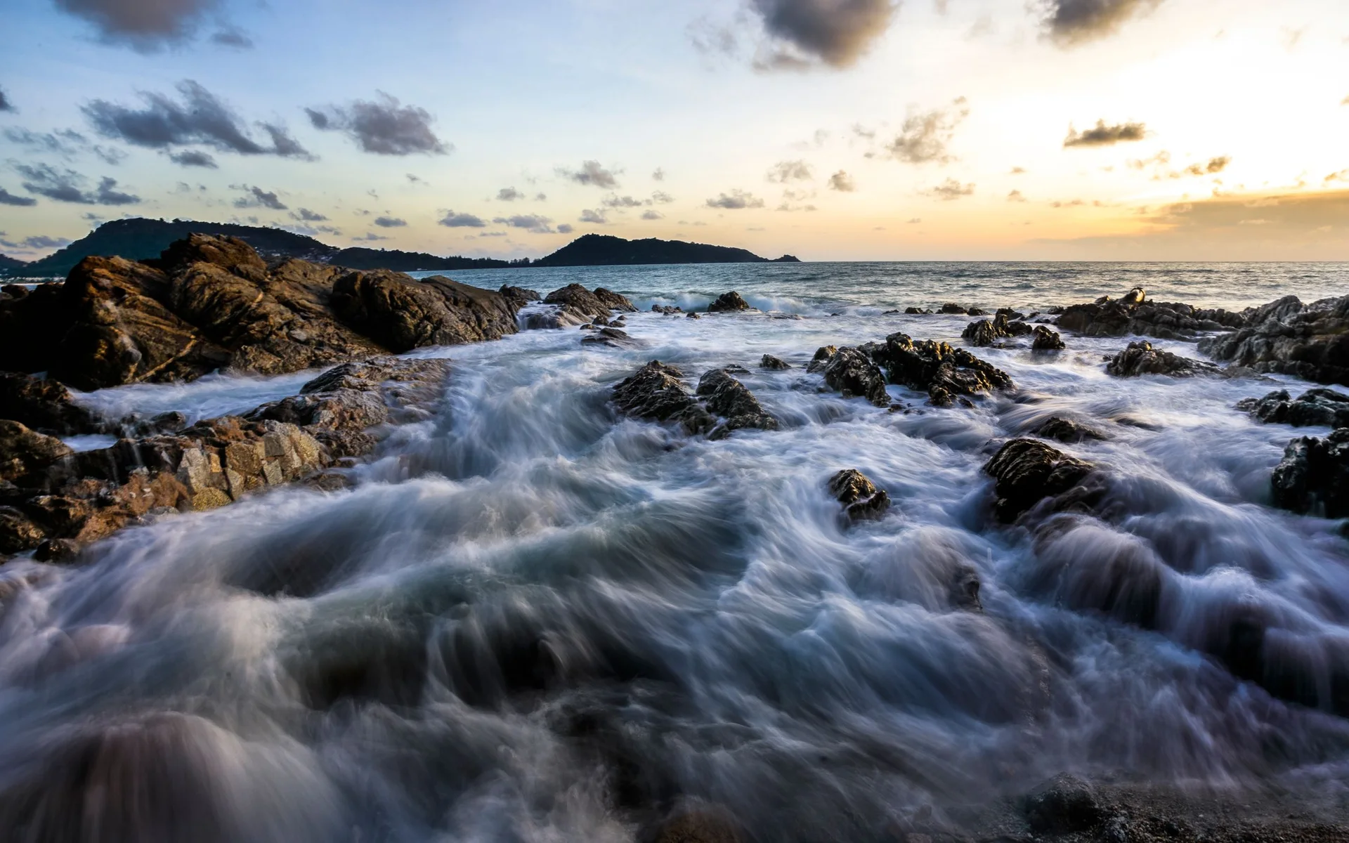 Waves along Phuket’s rocky coast at sunset