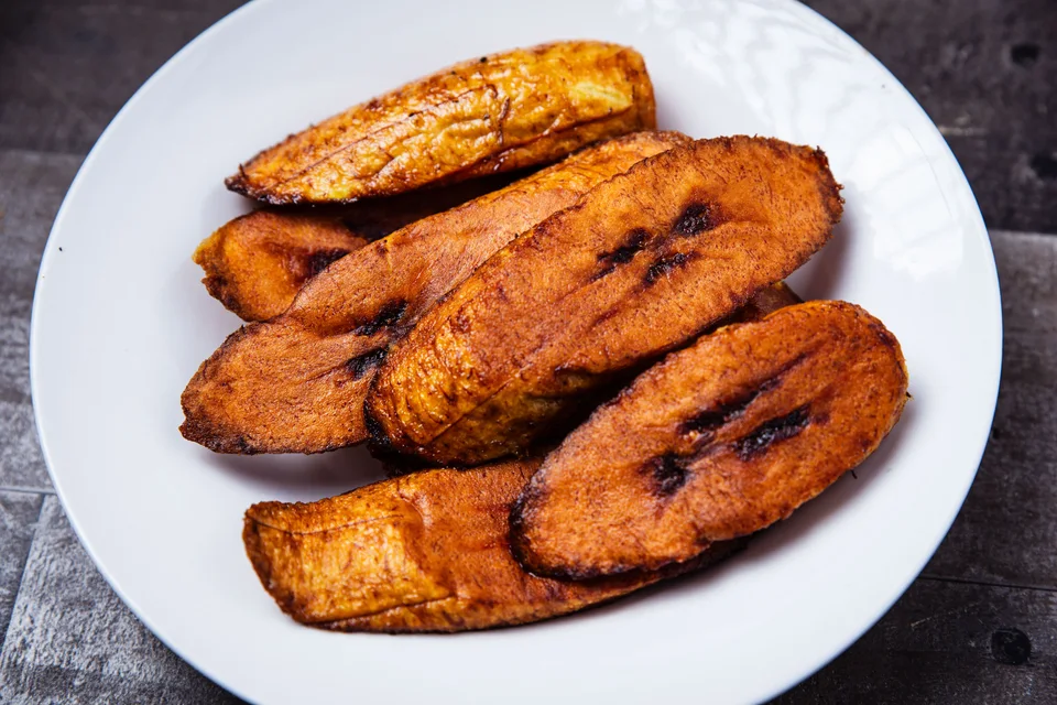 Voorbeeldfoto: Gebraaide plantain-skywe op 'n wit bord