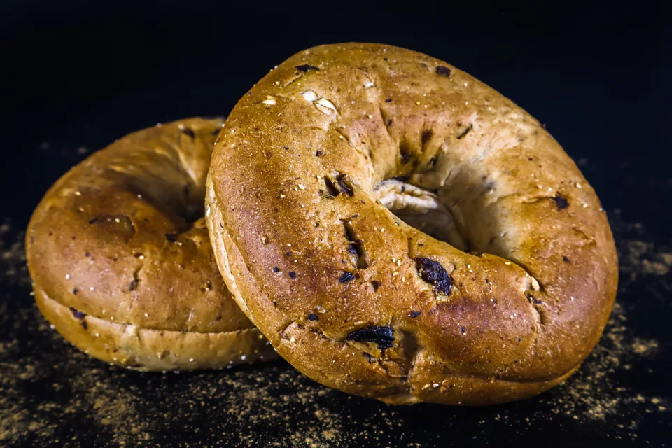 Voorbeeldfoto: Twee goudbruin bagels op 'n donker agtergrond
